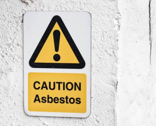 A danger sign warning people that a building contains asbestos.